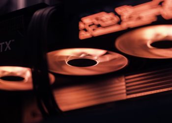 Dynamic close-up shot of illuminated gaming graphics card fans in red light, showcasing cutting-edge technology.