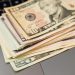 Stack of US dollar bills on a keyboard, symbolizing digital finance and wealth.