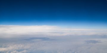 High-altitude view revealing the vastness of the sky with serene clouds.