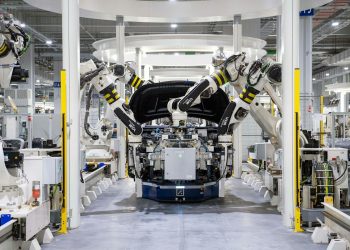High-tech robots assembling a car in a modern factory setting, showcasing automation.