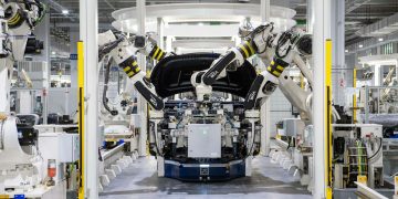 High-tech robots assembling a car in a modern factory setting, showcasing automation.