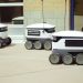 Autonomous delivery robots on a city sidewalk demonstrating modern technology for urban mobility.