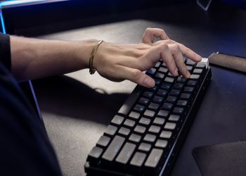 Close-up of a hand typing on a mechanical keyboard, highlighting modern technology and work.