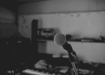 Artistic black and white shot of a music studio with a focus on a microphone. Perfect for music-themed projects.