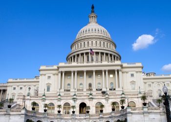 The United States Capitol Building in Washington, DC, with a clear blue sky.