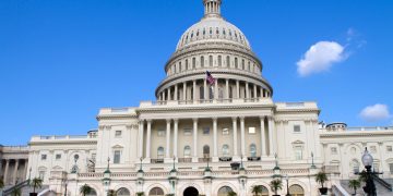 The United States Capitol Building in Washington, DC, with a clear blue sky.