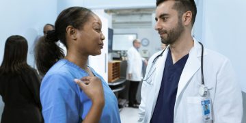 Medical professionals discussing patient care in a hospital hallway.
