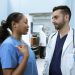 Medical professionals discussing patient care in a hospital hallway.