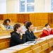 Students of various backgrounds attentively listening in a university lecture hall.