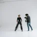 Photographer and model in a modern studio capturing stunning portraits on a white background.
