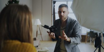 Photographer instructing model during an indoor studio session with professional lighting.