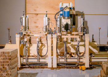 View of a complex woodworking machine in a factory setting, showcasing precision engineering and technology.