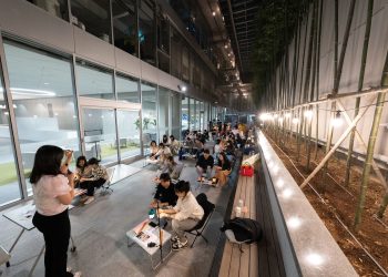 A nighttime educational workshop with instructor and engaged students in outdoor setting.
