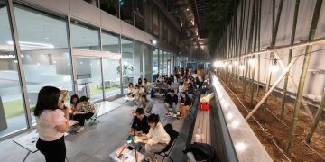 A nighttime educational workshop with instructor and engaged students in outdoor setting.