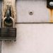 Close-up of a rusty metal padlock on a weathered door, highlighting security and decay.