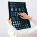 Doctor examines brain MRI scans closely for medical diagnosis in a hospital environment.