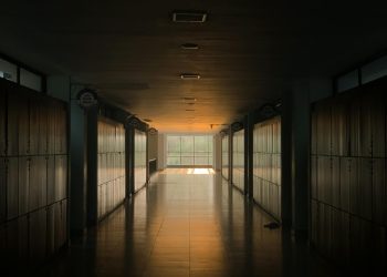 Peaceful school corridor at sunset with lockers and soft lighting.