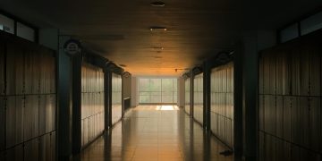 Peaceful school corridor at sunset with lockers and soft lighting.