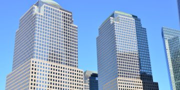 Stunning low-angle view of modern skyscrapers in downtown New York under a clear blue sky.