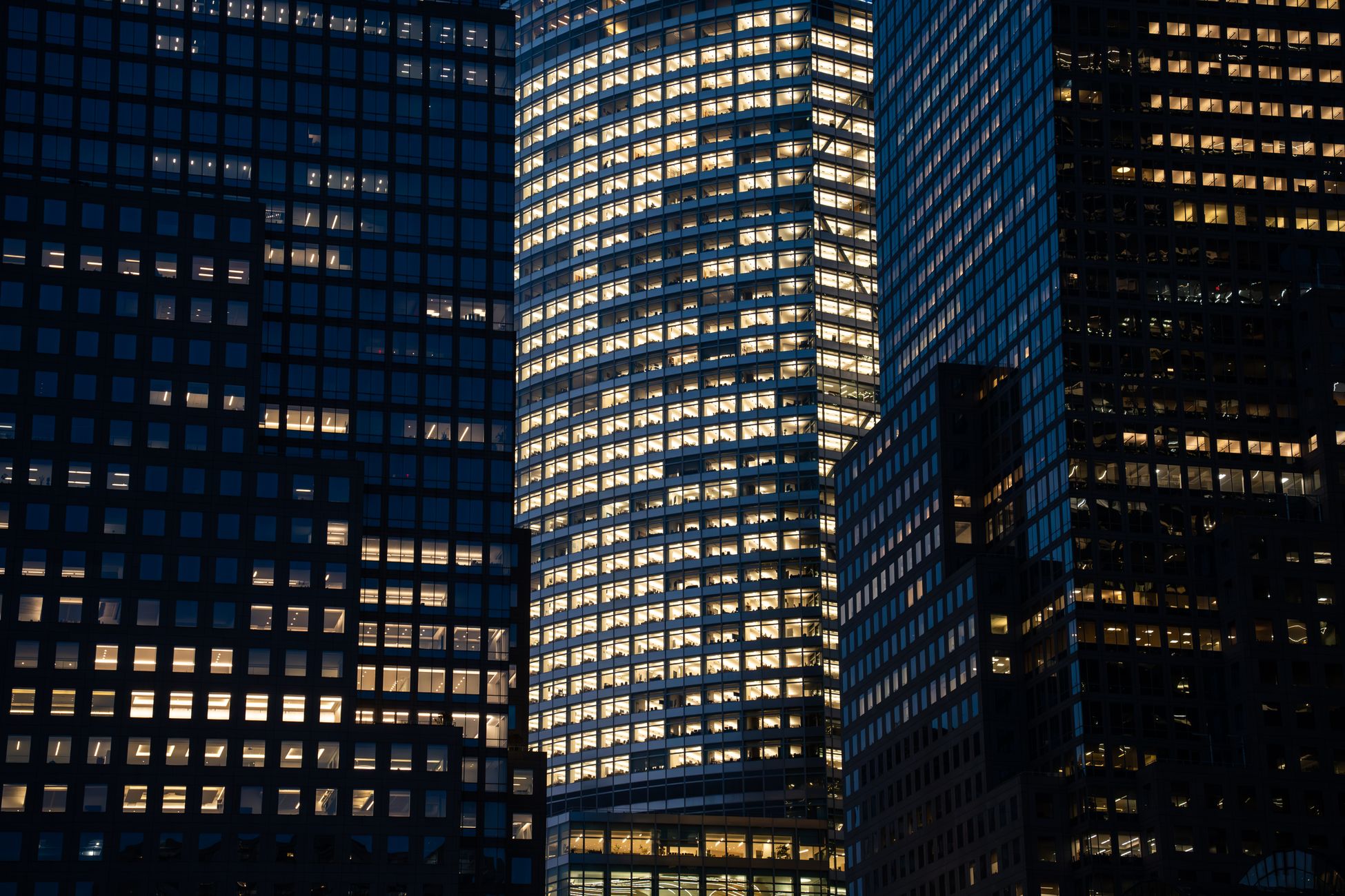 Skyscrapers with glowing windows create a vibrant nighttime cityscape.