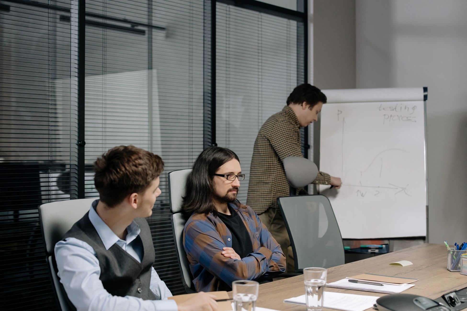 Team members discussing project strategy during an office meeting with charts and notes.