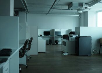 An empty modern office space in Kyiv featuring workstations, chairs, and technology.