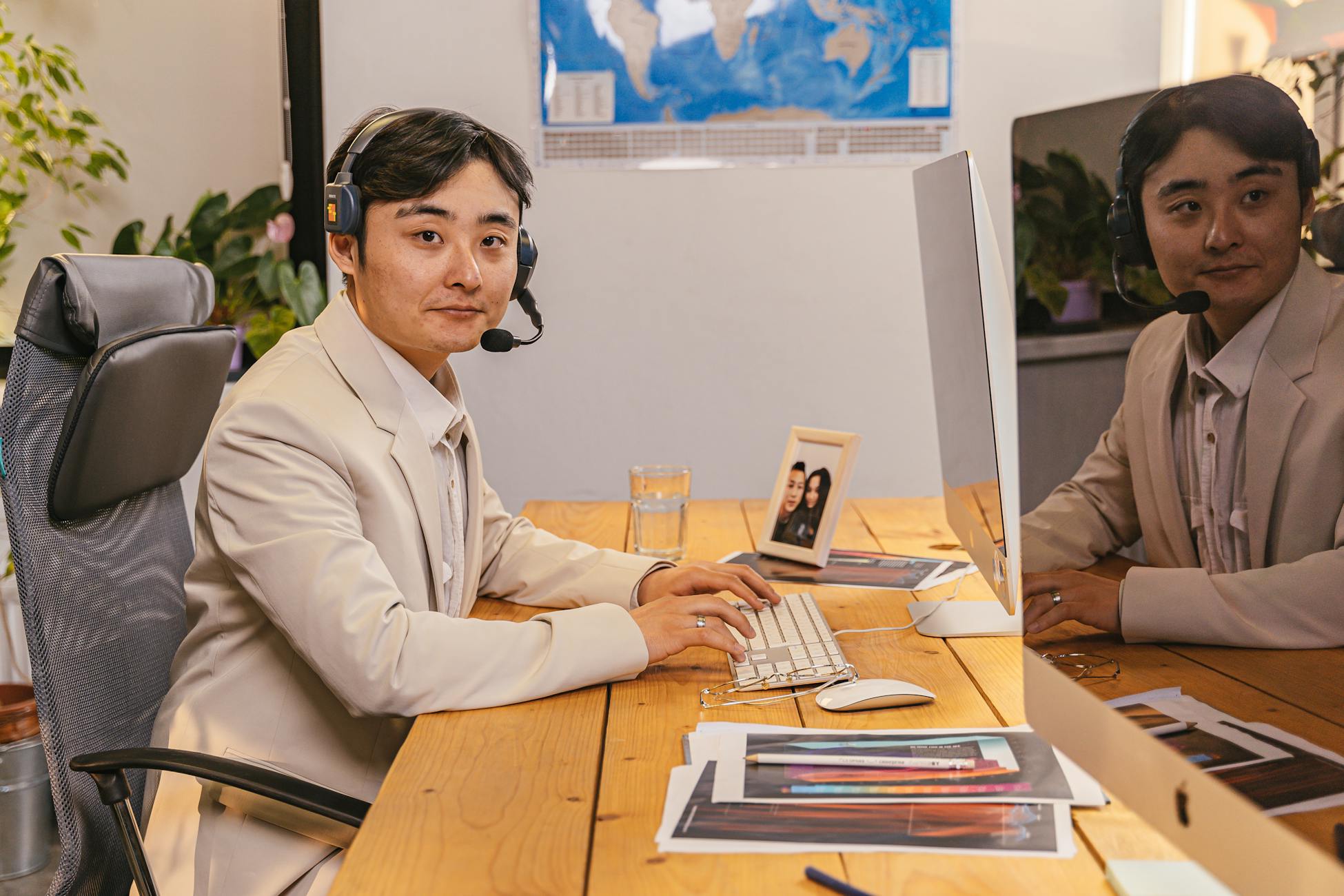 Man in business attire working at desk with headset reflects professionalism and modern office setting.