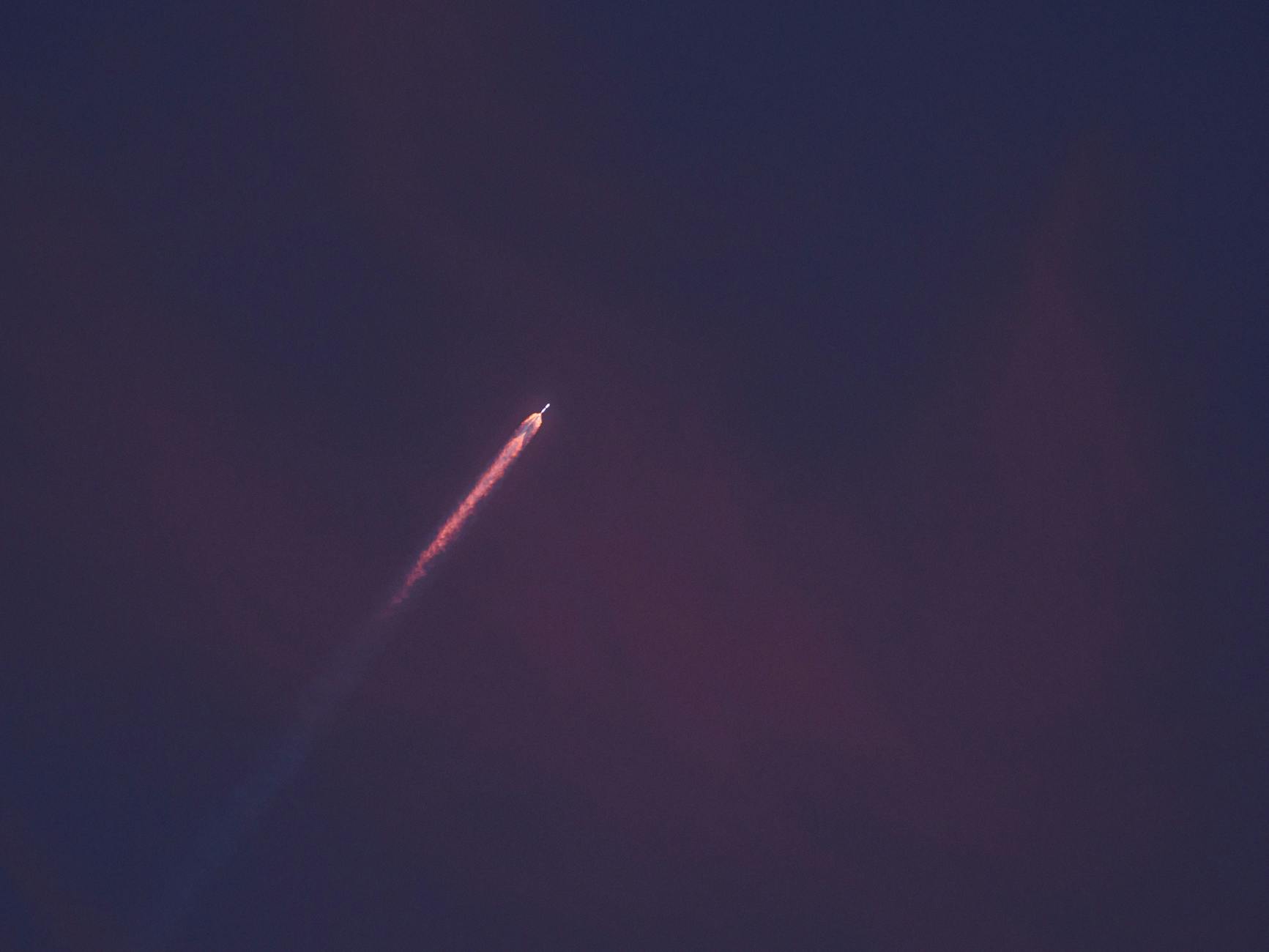 A stunning view of a rocket leaving a fiery trail as it ascends into the night sky.