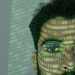 Close-up of a man with binary code projected on his face, symbolizing cybersecurity.