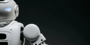 Close-up of a modern, monochrome robot arm against a dark background. Futuristic technology concept.