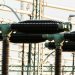 Close-up of outdoor electrical power equipment with insulators and conductors.