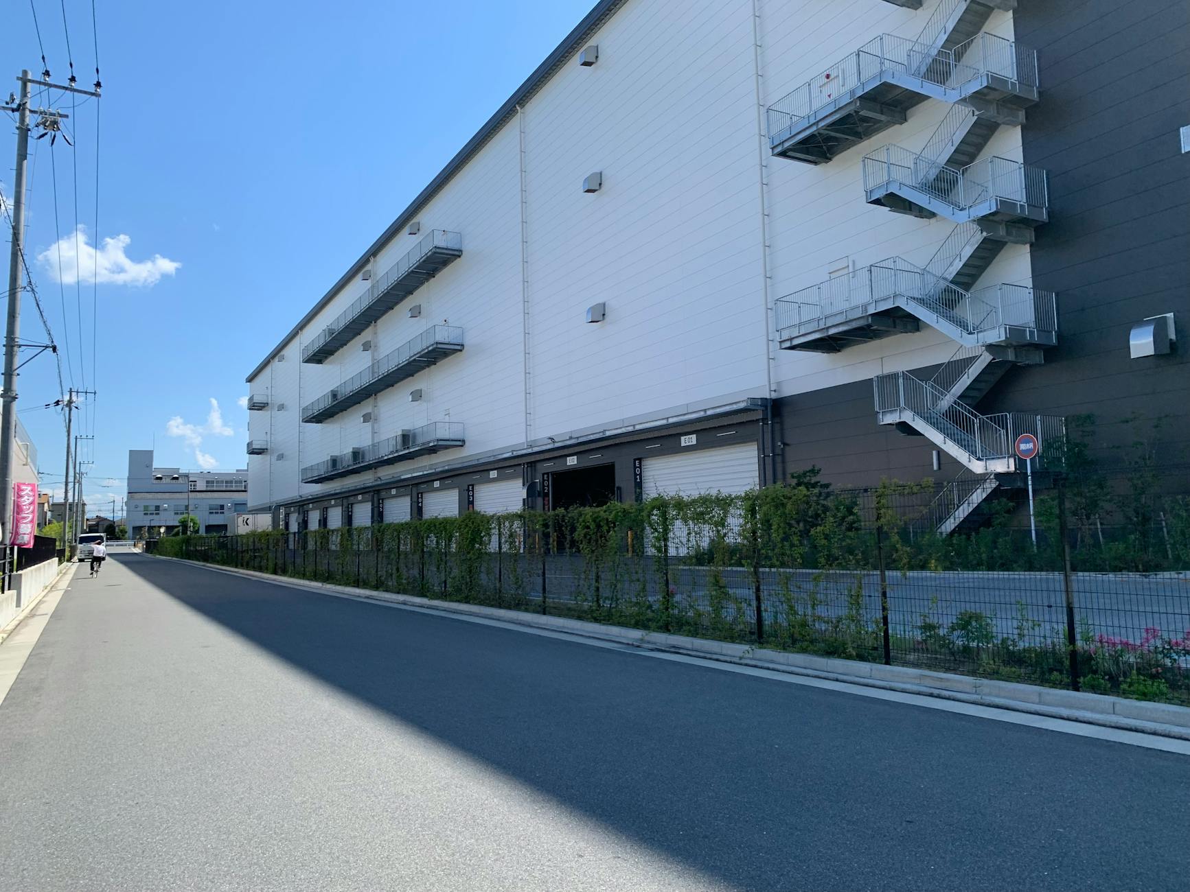 A large industrial building featuring outdoor staircases under a clear blue sky.