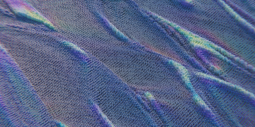 Colorful abstract pattern resembling digital waves with intricate texture in blue and purple hues.