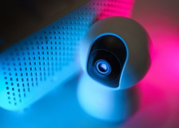 Close-up of a surveillance camera with neon lighting, symbolizing modern home security technology.