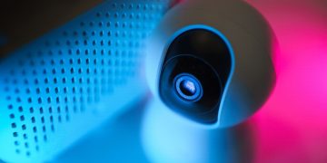 Close-up of a surveillance camera with neon lighting, symbolizing modern home security technology.