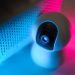 Close-up of a surveillance camera with neon lighting, symbolizing modern home security technology.