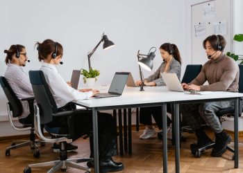 Team of diverse call center agents working diligently in a modern office setting.