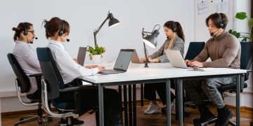 Team of diverse call center agents working diligently in a modern office setting.