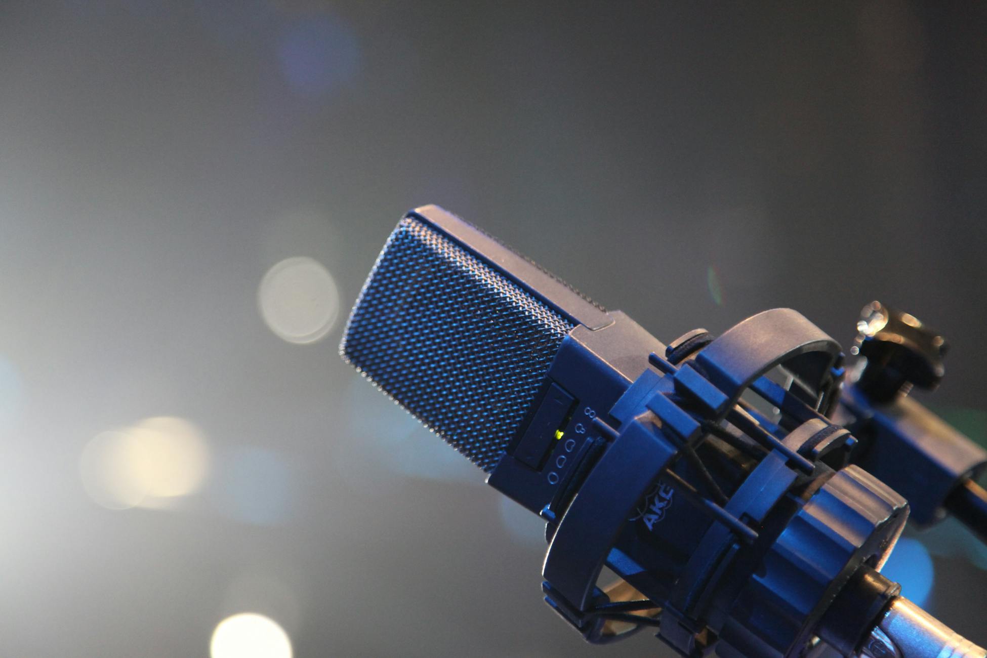 Close-up of a professional studio microphone with a bokeh backdrop, ideal for music and podcast imagery.
