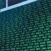 Vibrant green numbers on a computer screen, showcasing binary code and data streams.