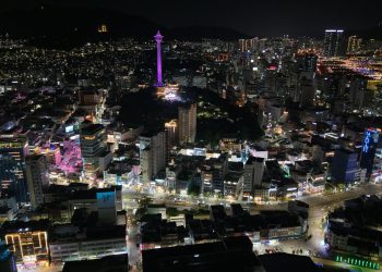 Stunning aerial night view of Busan city, highlighting Busan Tower in South Korea.