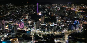 Stunning aerial night view of Busan city, highlighting Busan Tower in South Korea.