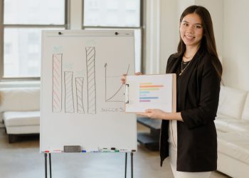 Woman presenting business data on clipboard with success graph in an office.