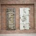 Two steel security vault doors attached to a vintage brick wall, showcasing industrial strength.