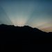 Silhouette of mountains with dramatic rays of sunlight at sunrise.