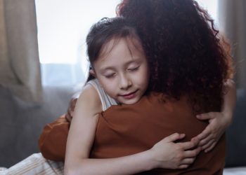 A heartfelt mother-daughter hug indoors, symbolizing love and connection.