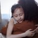 A heartfelt mother-daughter hug indoors, symbolizing love and connection.
