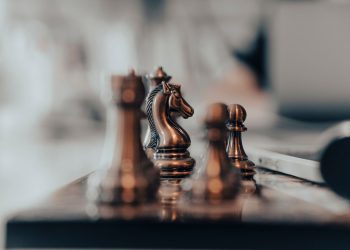 A detailed close-up of chess pieces on a board, highlighting the knight in warm tones.