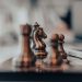 A detailed close-up of chess pieces on a board, highlighting the knight in warm tones.