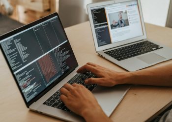 A developer working on a laptop, typing code, showcasing programming and technology skills.
